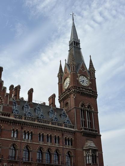 Clock Tower of St Pancras station in front of blue sky streaked with cirrus clouds