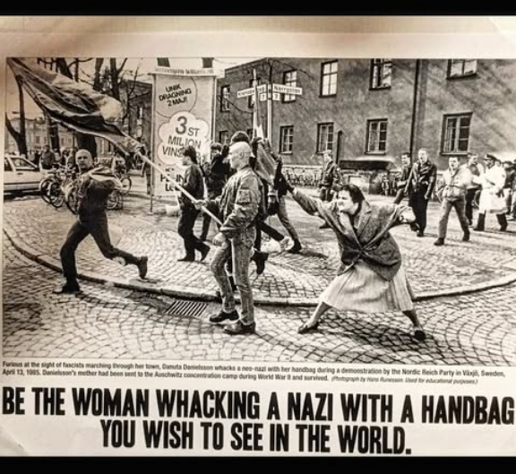 Iconic image of Danuta Danielsson, daughter of an Auschwitz survivor, whacking a Swedish neo-Nazi with her handbag at a march in the 80's. Caption "BE THE WOMAN WHACKING A NAZI WITH A HANDBAG YOU WISH TO SEE IN THE WORLD."