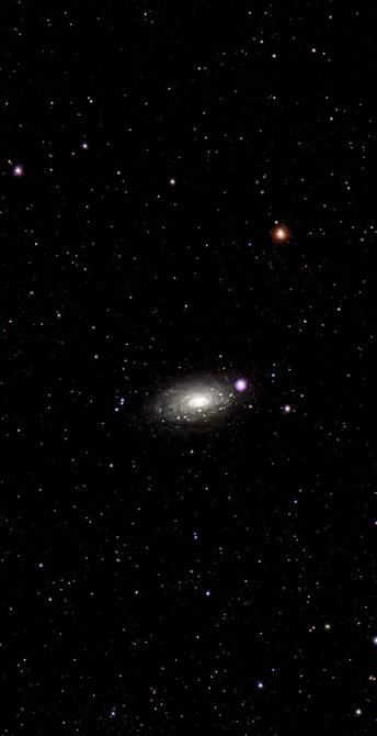 A distant galaxy surrounded by numerous stars and cosmic bodies against a dark background of space. The galaxy appears elongated with a bright core and clusters of stars scattered throughout the scene.

Odległa galaktyka otoczona licznymi gwiazdami i ciałami kosmicznymi na ciemnym tle kosmosu. Galaktyka wydaje się wydłużona z jasnym jądrem i gromadami gwiazd rozrzuconymi po całej scenie.