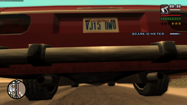 The image is a screenshot from a video game, showing a red vehicle from a rear perspective. The vehicle has a license plate reading "VJ15 OWO" and a "SCARE-O-METER" displayed on the screen, indicating a gameplay element. The vehicle's bumper and exhaust pipes are visible, along with the rear wheels. The environment appears to be a desert-like area with a dirt road. The top right corner of the screen shows a mini-map, a time indicator "09:32," and a score or money amount "$00056254." The bottom left corner features a compass. The overall color scheme is dominated by reds and browns, with the vehicle's red body contrasting against the sandy background.