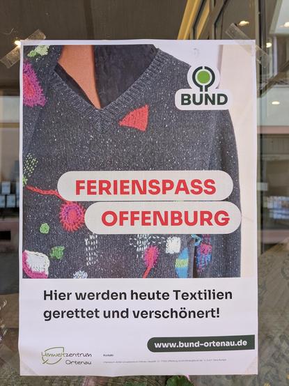 Plakat mit der Aufschrift "Ferienspass Offenburg - Hier werden heute Textilien gerettet und verschönert", dazu das BUND_Logo und das vom Umweltzentrum. Auf dem Bild des Plakates sieht man einen Pullover mit Flicken.
