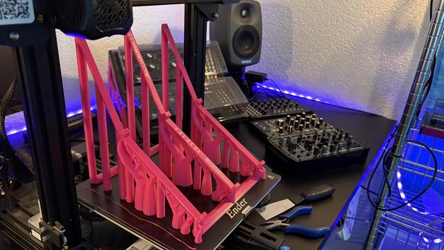 The final stages of the 3d printing itself, last minutes before the new supports for my semi modular synths were done. Lots of pink printed PLA pillars visible, with some grid-like beams about to be holding up the synths themselves.