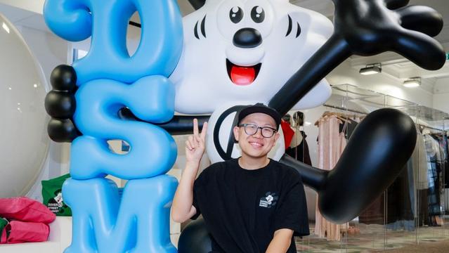 Verdy posing with Vick, the artist's signature cartoon character, holding a DSM sign at Dover Street Market in London.