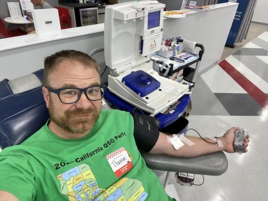 A man in a green shirt donates blood