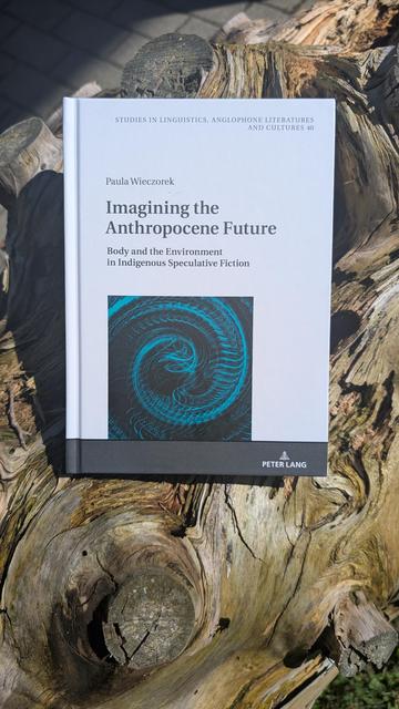 Paula Wieczorek's book "Imagining the anthropocene future" on a large tree trunk with lots of swirly snags