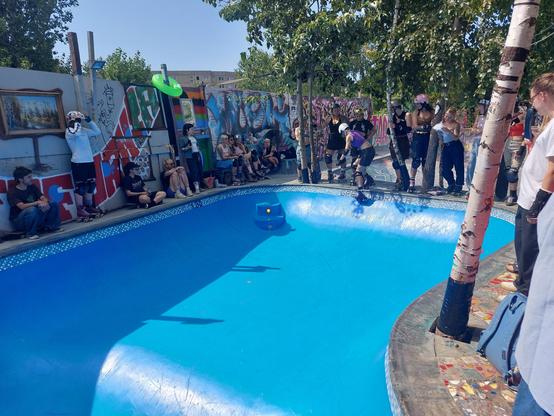 A rollerskater does a stall at a blue pool