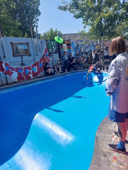 A skater does a laid back 50-50 grind over a small step in a pool