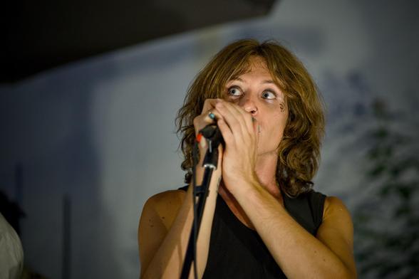 Ein Sänger mit langen Haaren am Mikrofon.