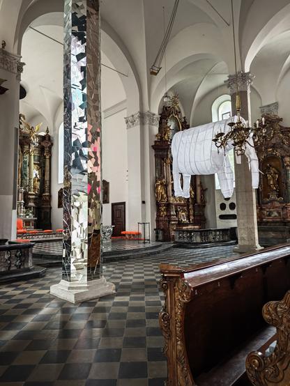 In der gleichen Kirche wie oben steht eine Säule, die mit vielen Spiegelscherben beklebt ist. Im Hintergrund der Elefant.