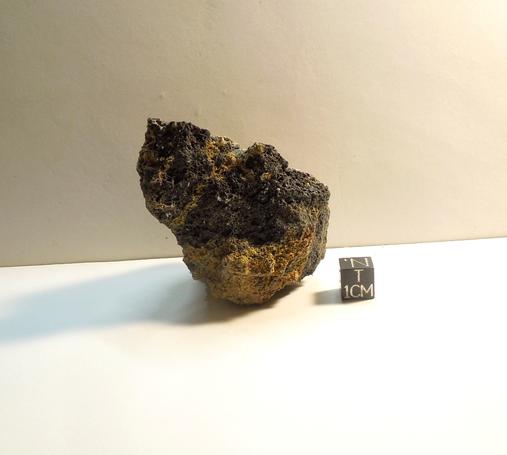 A small piece of Pica Glass placed near a black centimeter scale cube.