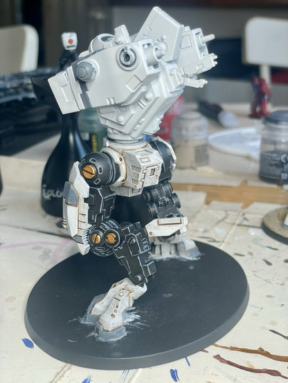 Rear view of t’au riptide battlesuit in process of being built and painted. Legs are fully painted, but the torso only has base paints and now arms or head has been attached.