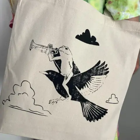Froggy and bird friend riding through the air, just tootin' on a tote bag.