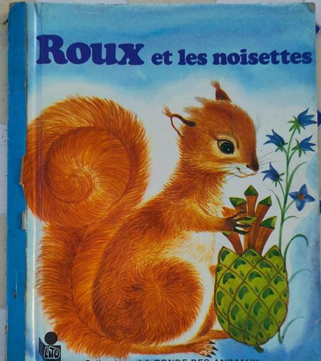 Couverture du livre pour enfant "ROUX et les noisettes" 1979 avec un écureuil qui mange une noisette?