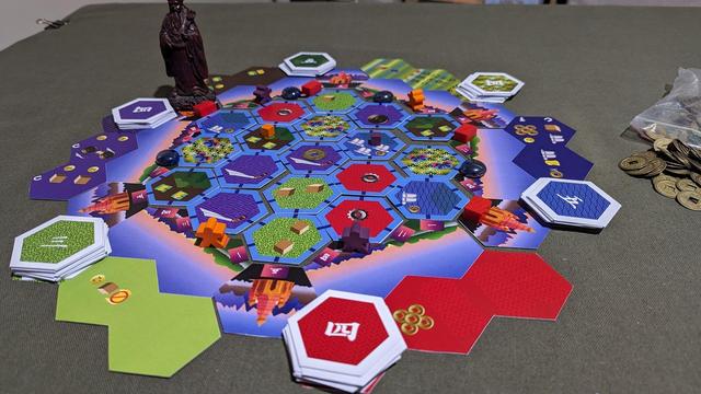 A hexagonal, multicoloured board for the game Land of Gold.