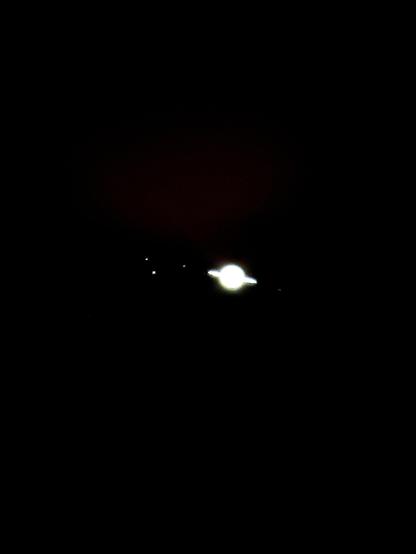 A bright white Saturn is a little fuzzy due to high contrast in order to get the tiny moons around the planet. To the left is Tethys, Rhea and Titan to the right is Dionne.