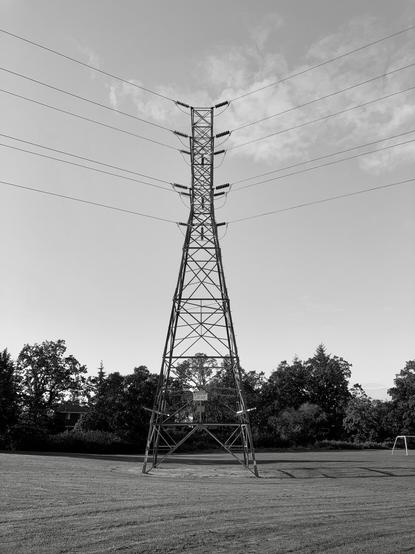Transmission tower in playground near football goal.
