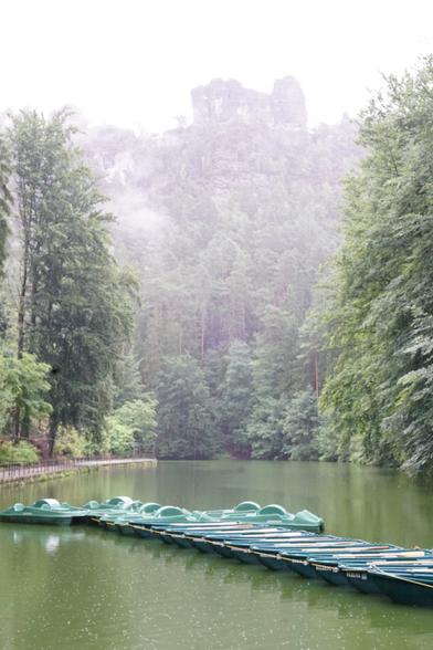Tretboote und Wald um den See
Nebelig/Regen darüber