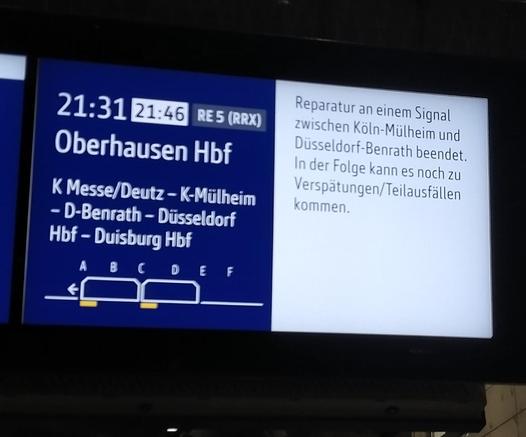 Picture showing that a train is late by 15 minutes. A sign next to it tells about delays due to a broken signal.