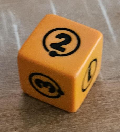 Orange D6 die with dark blue markings of numbers in a circle, 2 face is up.