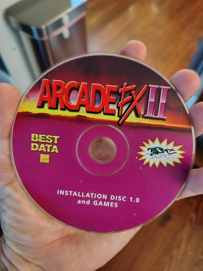 Hand holding CD that says Arcade FX II Installation Disc and Games.