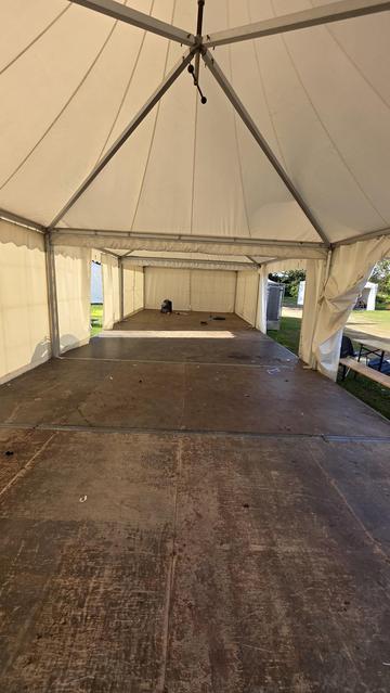 an empty village tent. in the back my backpack and luggage are left on the floor, ready to be picked up