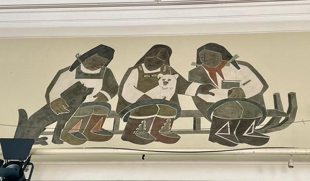 Ein Detail an der Decke des Saales: ein Bild mit drei Menschen in Tracht, die auf einem Schlitten sitzen und zwei Hunden