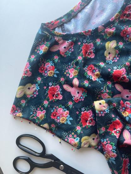 There’s a T-Shirt with a bunny &amp; flowers pattern. It’s not finished, the arm is prepped with needles.