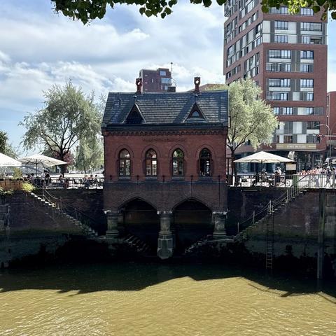 A small dark red brick building called Fleetschlösschen at a canal at the Speicherstadt.