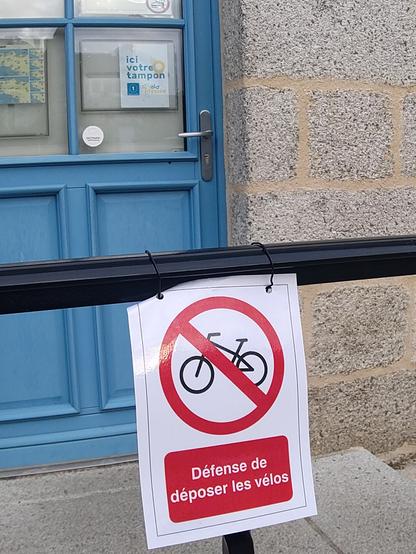 Sur la photo on voit deux messages : 
"Ici, on tamponne pour l'Eurovelo 1"
Et "Défense de stationner les vélos"