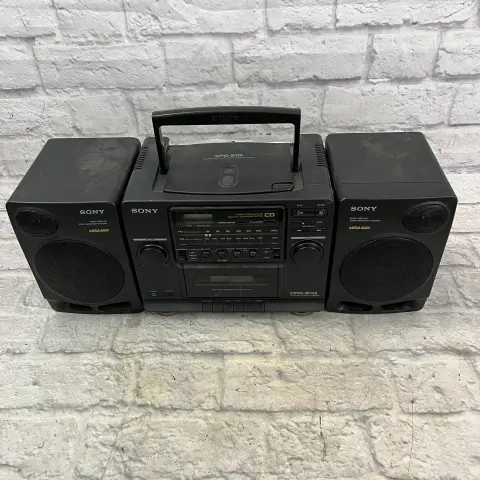 Photo of a black Sony CDF-510 CD/Radio/Cassette player, positioned on some white painted bricks.