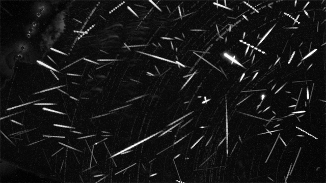 Zwart-wit lage resolutie plaatje met daarop veel meteoren als korte streepjes.