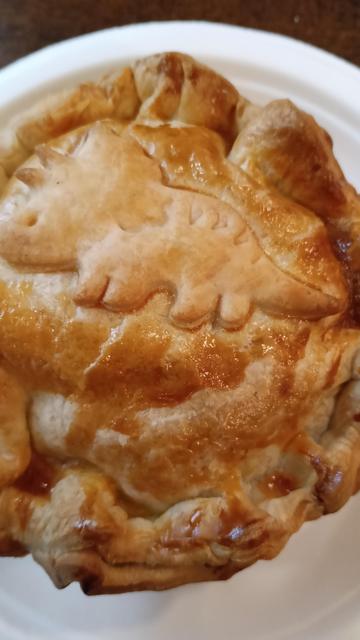 a New Zealand pie with a triceratops shaped bit of dough baked on top