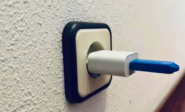 USB stick plugged into a charger block which is plugged into an outlet.