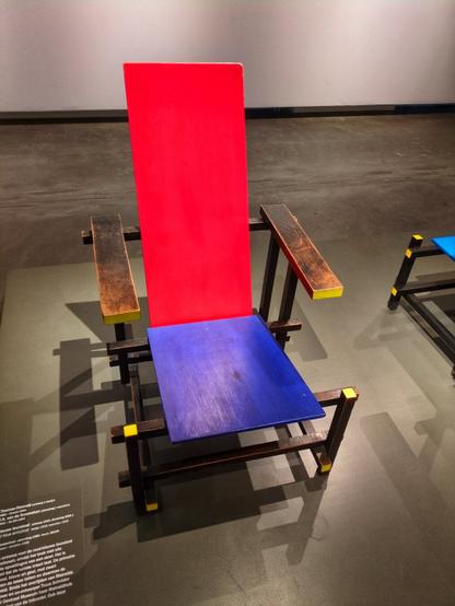 Reitveld's pioneering red and blue chair, from 1923. His designs were based on bold primary colours and geometric shapes. In this case, a blue square seat, a rectangular red back, with black rectangular chair legs.