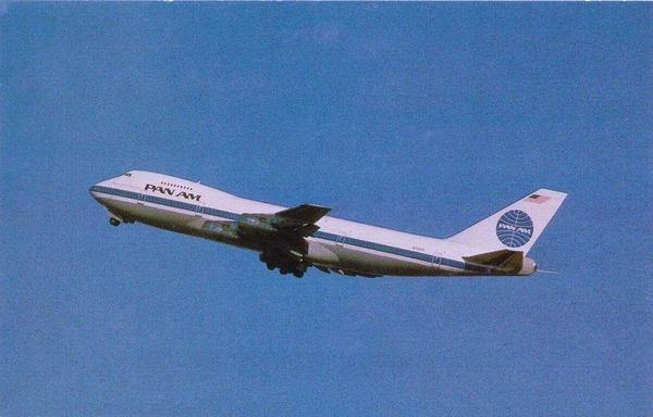 A Pan Am Boeing 747 is depicted in flight against a light, somewhat textured, cerulean blue sky. 

The plane is angled slightly, with the fuselage and tail visible. The distinctive Pan Am logo appears on the tail fin and also on the body of the aircraft. The plane's body is predominantly white with blue markings. The image has a vintage aesthetic, from the postcard, and the colors and texture give it a slightly grainy or slightly pixelated appearance.