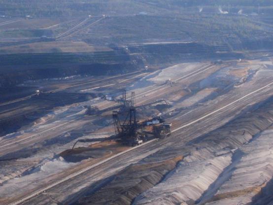 A huge excavator is doing its work of lignite mining. It moves in a huuge hole and, together with many "colleagues," transforms it into an abstract work of art dominated by beige and brown tones.
According to Wikipedia (https://de.wikipedia.org/wiki/Rheinisches_Braunkohlerevier), "the Rhenish Lignite Mining Region is a mining region in the Cologne Bay, on the northwestern edge of the Rhenish Slate Mountains. Open-pit lignite mining has significantly transformed the landscape here and led to the development of several important industrial sites. The region encompasses the Zülpich and Jülich Börde, the Erft Lowlands, and the Ville region.

The Rhenish Lignite Mining Region is one of the largest lignite mining regions in Europe. Clay, quartz sand, and loess are mined here to a lesser extent.

The industrial use of the region, including the entire value chain from coal mining to electrical power generation, is currently managed exclusively by the RWE Group (through its subsidiary RWE Power).

According to current plans, mining in the Rhenish Lignite Mining Region is secured until 2030. Forecasts regarding future developments are difficult, as a central pillar of Germany's energy transition is a coal phase-out."