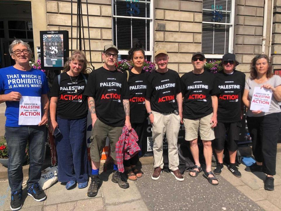8 protesters wearing various t-shirts condemning the proscription of Palestine Action