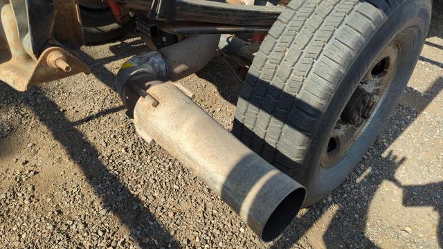 Closeup of a truck exhaust which has been reworked to exit perpendicular to the truck frame and just past the rear wheel. Of particular interest is the excellent welding used to extend this exhaust tube; it's really clean work.
