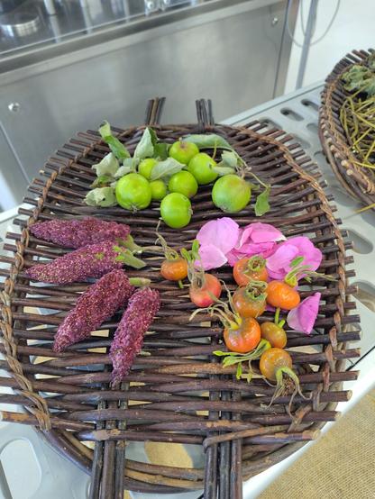A crate with sumac flowers, rose hips and petals and unripe apples.