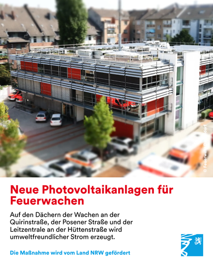 Moderne Feuerwache mit roten Akzenten und installierten Photovoltaikanlagen auf dem Dach in einem Wohngebiet.