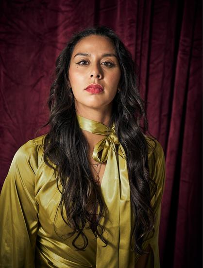 Woman with long dark hair in a gold dress