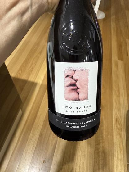 A bottle of Two Hands 2022 Cabernet Sauvignon named “Sect Beast” and the picture is an artistic close up of two people kissing.