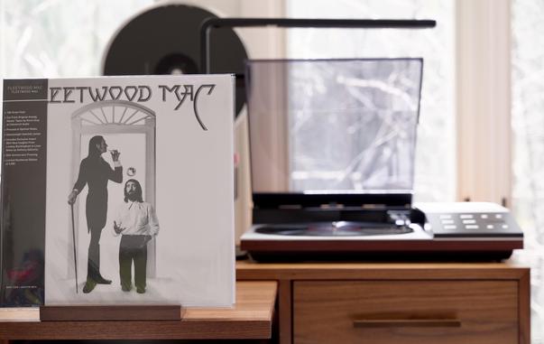 Fleetwood Mac - s/t LP cover.

White background, a doorway with mick Fleetwood, tall with a cane, and John McVie, looking tiny (clearly kneeling on shoes), juggling. The Rhino High Fidelity OBI covers the left side.

The black LP plays on a vintage, restored Bang & Olufsen Beogram 8002 linear-tracking turntable to the right.