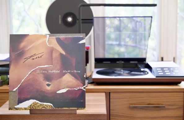 Juliana Hatfield - Made in China LP cover.

The original cover was a photo of Juliana’s abdomen. This is that, but with part of it being painted (by Juliana) rather than photographed. Her signature, and the year 2025, appears as well.

The black LP plays on a vintage, restored Bang & Olufsen Beogram 8002 linear-tracking turntable to the right.
