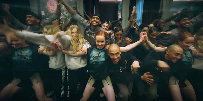 Un plan sur un groupe de danseurs dans un pose à la fois joyeuse et bizarre.