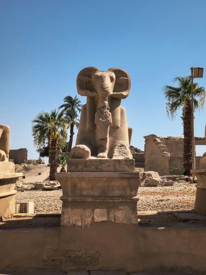 Statua di una Sfinge con testa di Ariete e un piccolo umano tra le zampe anteriori