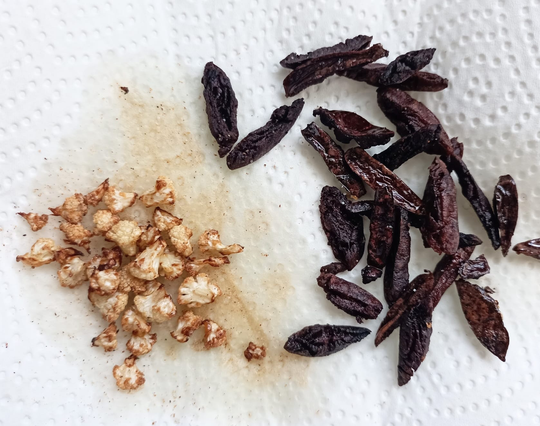 Auf kÜchenpapier gebratene winzige Blumenkohl-Röschen und gebratene Oliven-Streifen