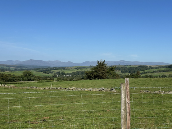 A view of a landscape. In the distance is a range of mountains.