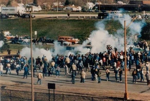 Image of striking Hormel workers out in the street on sunny day, with lots of smoke.
