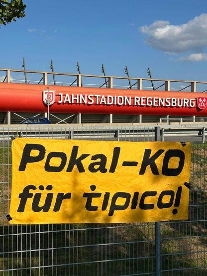 Banner mit der Ausschrift "Pokal-KO für Tipico!" vor dem Jahnstadion in Regensburg